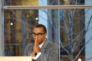 Dr. Claudine Gay at podium being cheered as president-elect of Harvard with hands together over mouth