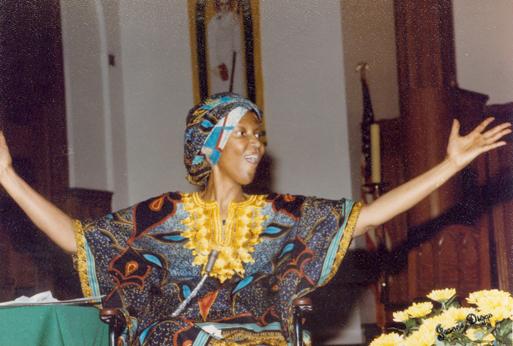 Sister Thea Bowman smiling with arms extended inside of a church