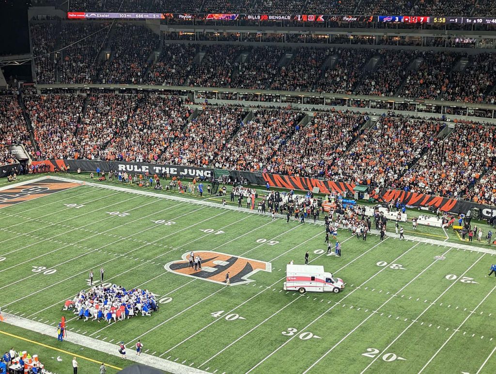 Buffalo Bills, at the bottom left, kneeling in prayer after Hamlin's cardiac arrest