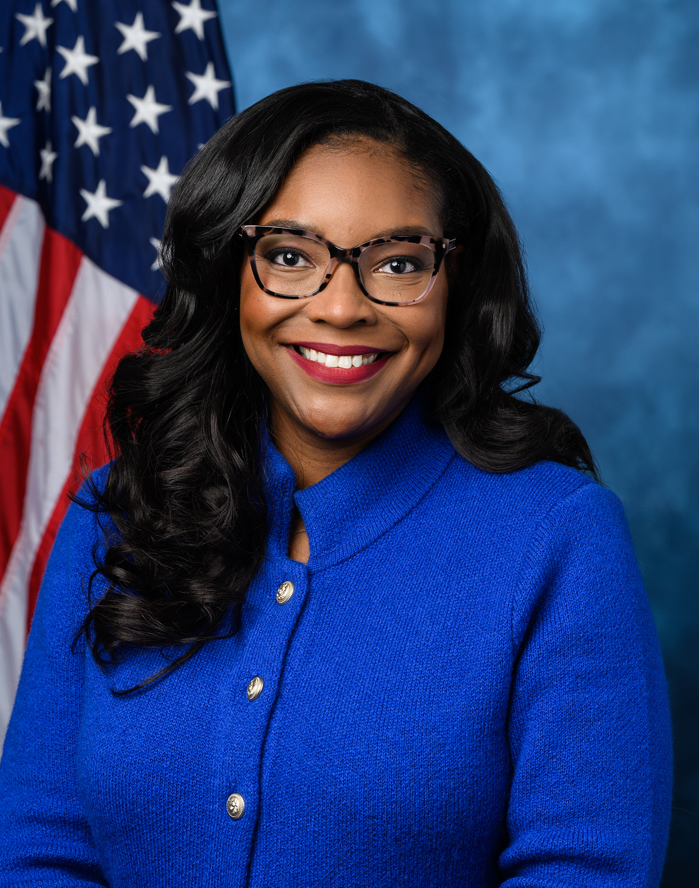 Representative Emilia Skyes posing in front of American flag