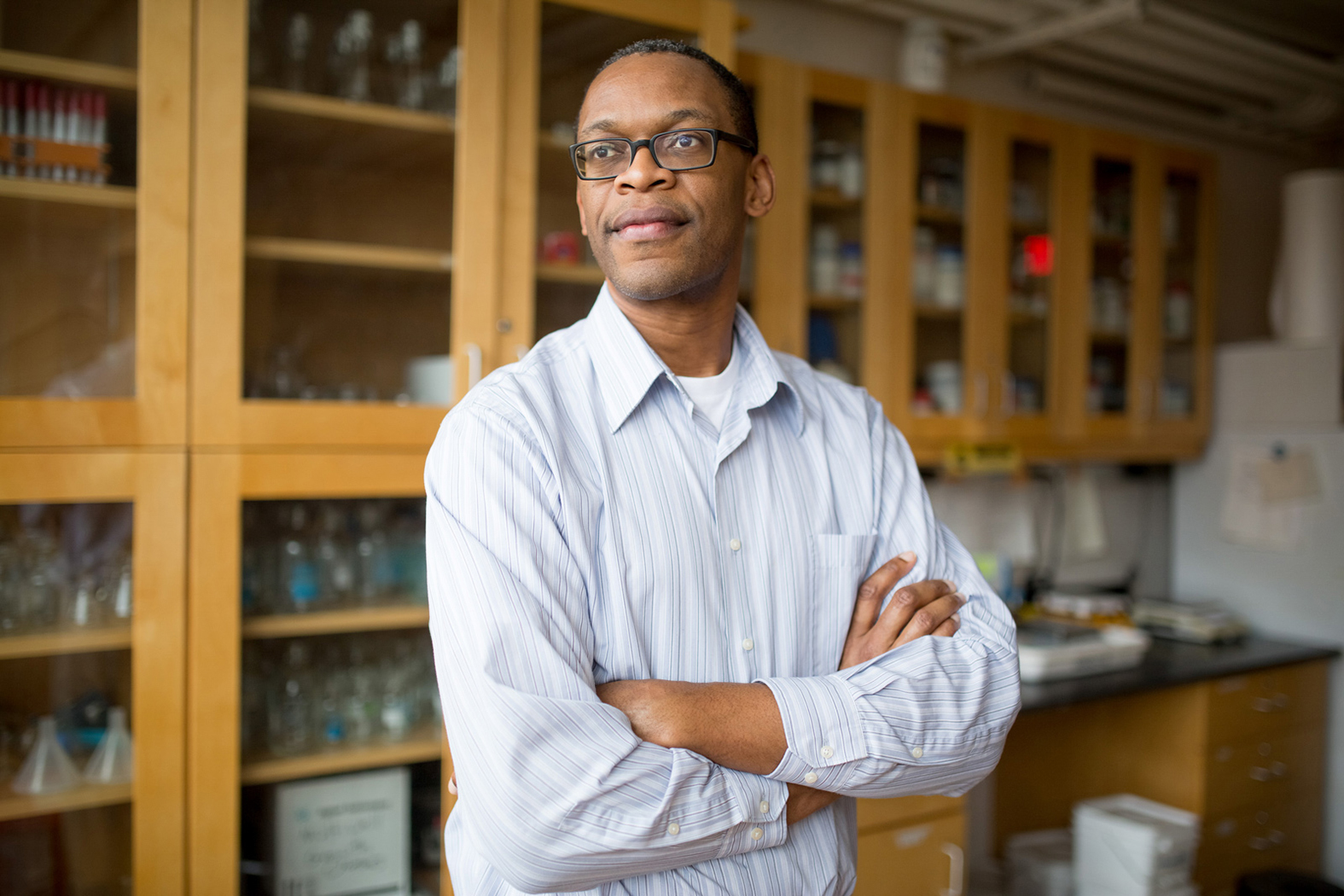 Niles posing with arms folded in laboratory