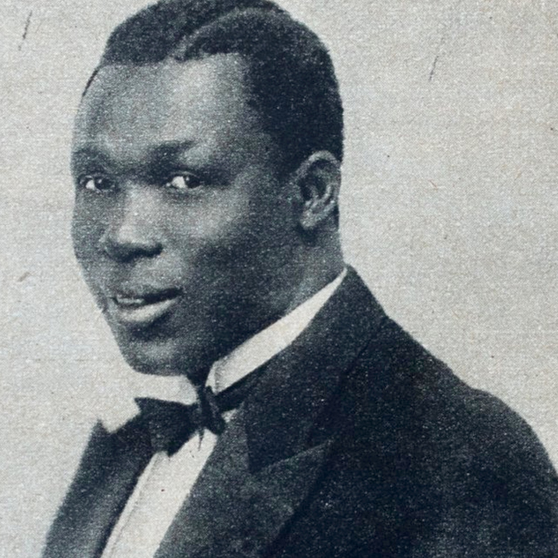 Browne in a black and white publicity photo wearing a tuxedo|Grey stone monument with a picture of Browne in tuxedo