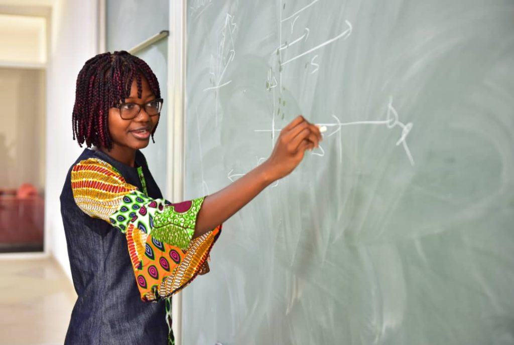 Tabiri writing on chalkboard