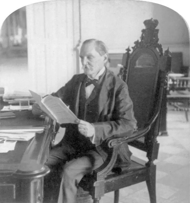 Palma sitting at desk reading a folded sheet of paper